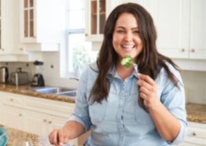 Woman eating broccoli