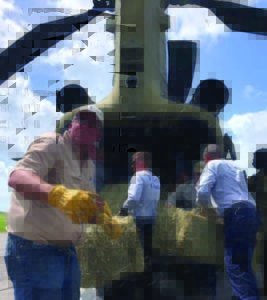 Men hauling hay out of a helicopter